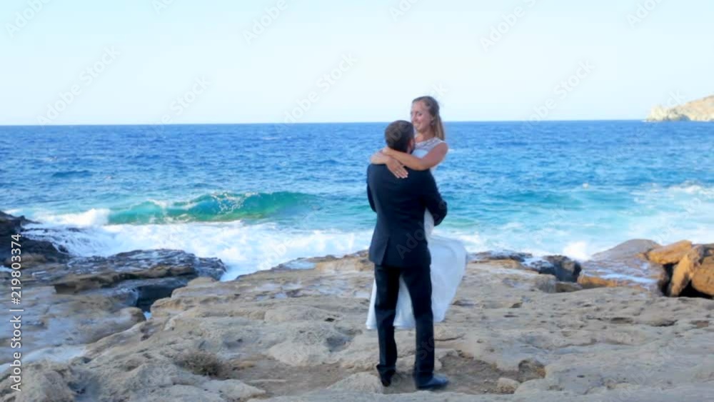 Happy Bride and groom on the seashore on their wedding day. The concept of a happy family life. Wedding photosession. Greece Happy Bride and groom on the seashore on their wedding day. The concept of a happy family life. Wedding photosession. Greece