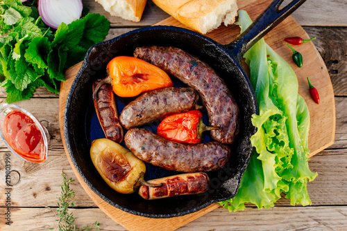 Oktoberfest. Fried lamb sausages and sweet peppers on a cast-iron frying pan photo