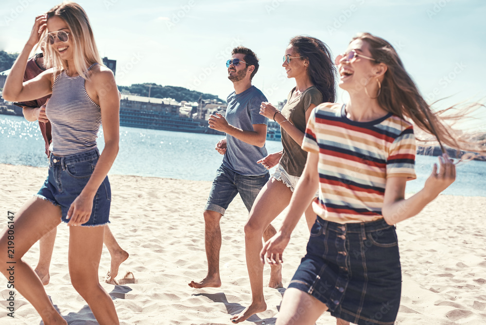 Friends on the beach. Happy young friends group have fun and celebrate while jumping and running on the beach. Friends on the beach. Happy young friends group have fun and celebrate while jumping and running on the beach.