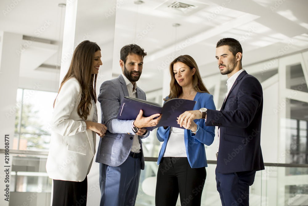 Young business people standing and analyzing documents Young business people standing and analyzing documents