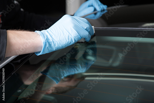 Worker applying ceramic coating on car windscreen © camerarules