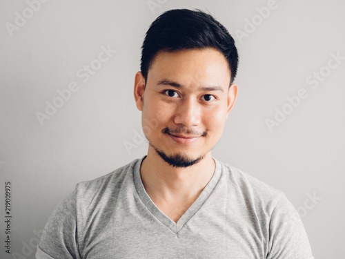 Headshot photo of Asian man with happy face. on grey background.