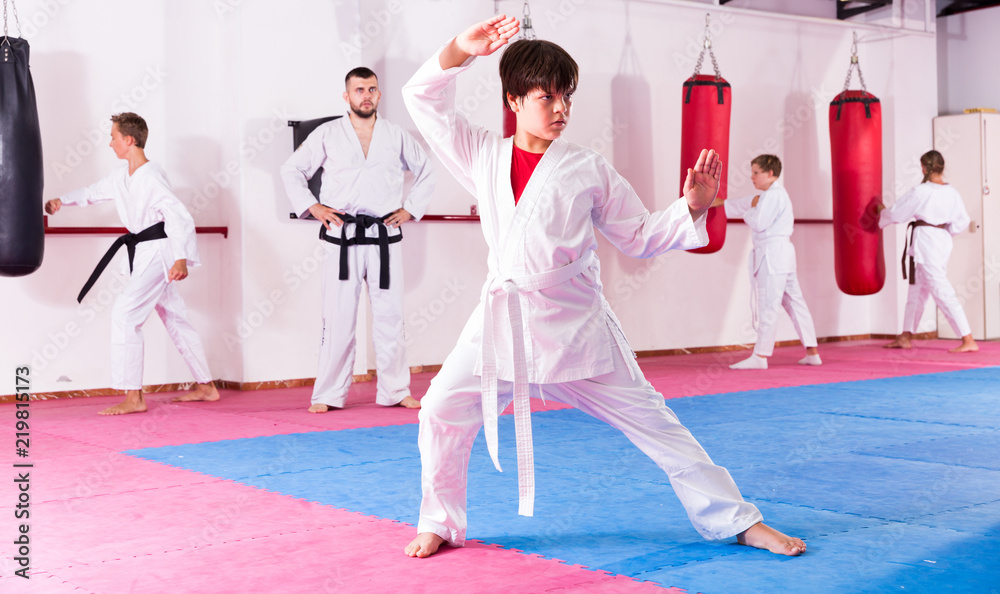 Boy training karate movements in gym
