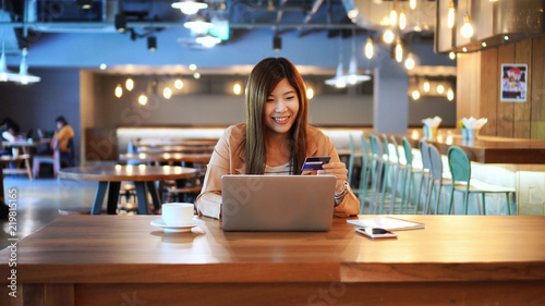 Obraz na płótnie Asian businesswoman in casual suit using the credit card with computer for online shopping at co-working space, business technology and lifestyle concept w salonie