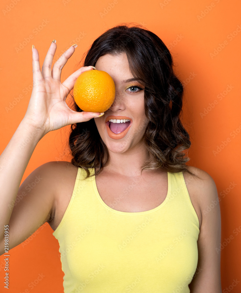 Young cheerful woman holding orange Young cheerful woman holding orange