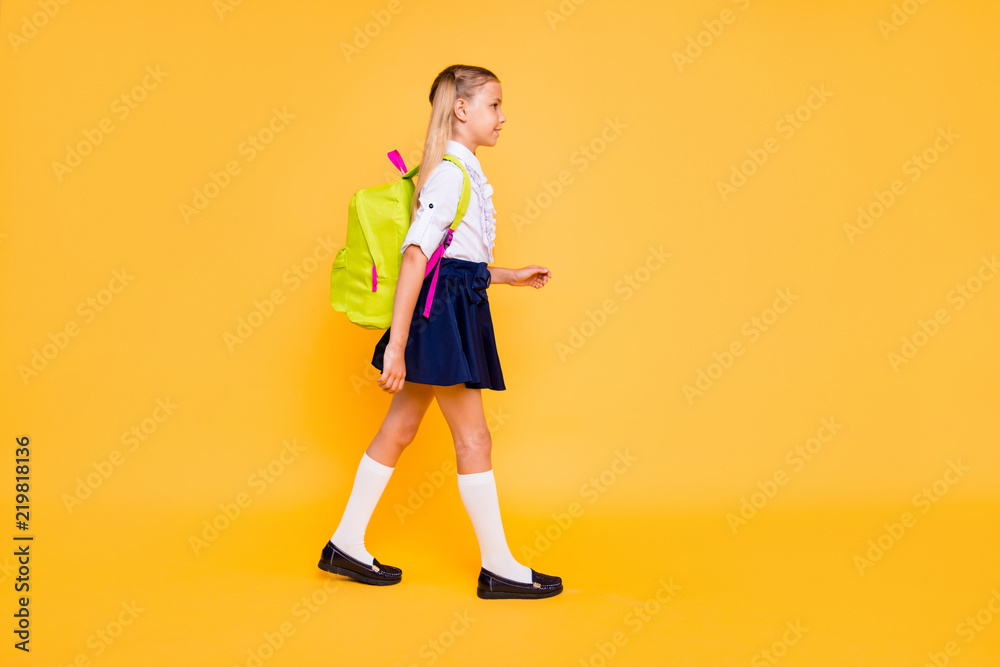1-september concept. Full length, legs, body, size vertical profile side view photo of small girl isolated on yellow background with yellow backpack on shoulders 1-september concept. Full length, legs, body, size vertical profile side view photo of small girl isolated on yellow background with yellow backpack on shoulders