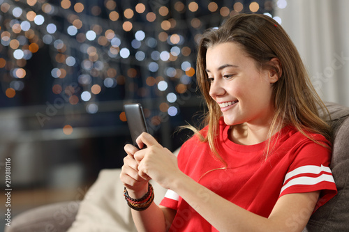 Teen using a smart phone in the night at home
