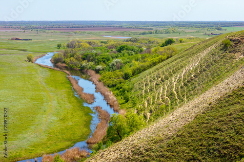 Sunny landscape with the quiet plain river under steep hillside. White river, Russia, Rostov-on-Don region