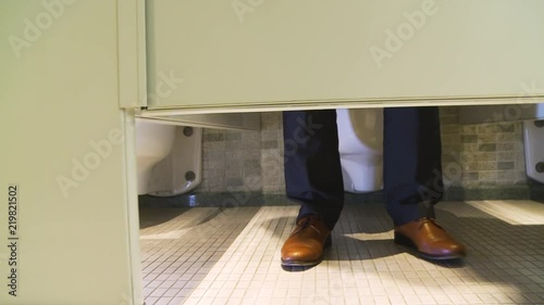 A Man Pulling His Pants Down to Use the Washroom