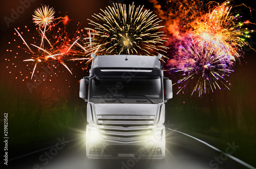 Lastkraftwagen bei Nacht mit Feuerwerk im Hintergrund. - Truck at night with fireworks . New Year wishes with fireworks and space for text for logistics companies or forwarding agents