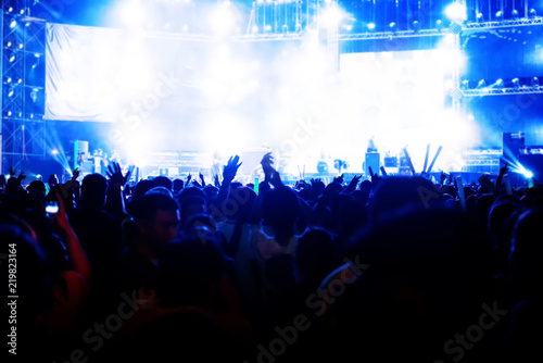 Blurred image of concert Crowd Cheering fans during live music with singer song on stage
