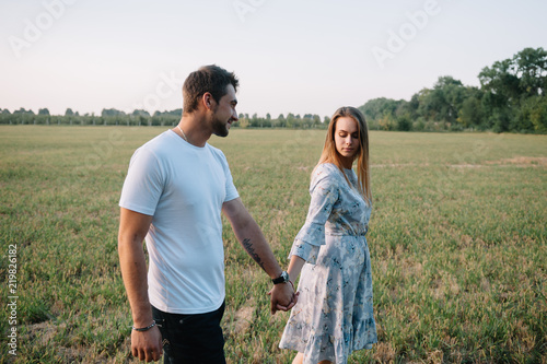 A girl and a guy are walking in the park. Portrait of a couple, a love story. Happy smiling, loveling couple together outstretched at beautiful nature. Lovestory photo