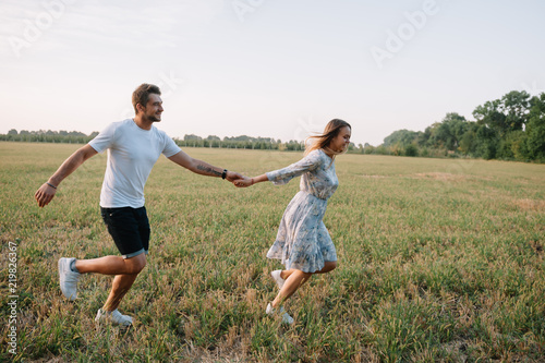 A girl and a guy are walking in the park. Portrait of a couple, a love story. Happy smiling, loveling couple together outstretched at beautiful nature. Lovestory photo