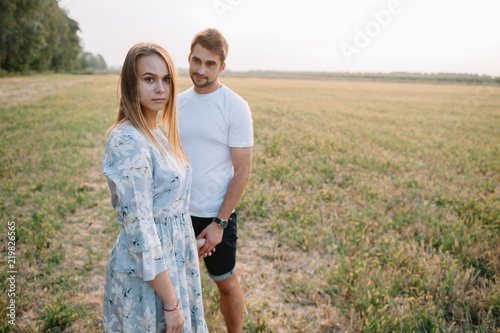 A girl and a guy are walking in the park. Portrait of a couple, a love story. Happy smiling, loveling couple together outstretched at beautiful nature. Lovestory photo