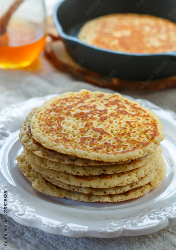 Delicious sweet American pancakes with honey on a white plate. Breakfast is gourmet