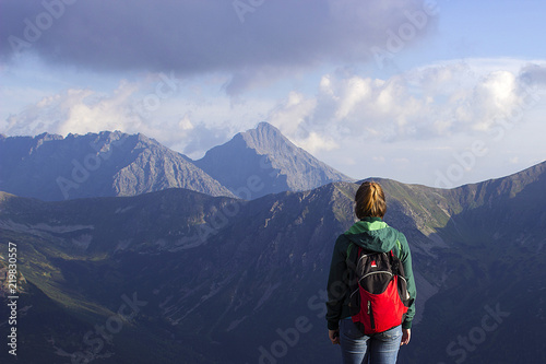 A young woman is standing with her back on a nature background