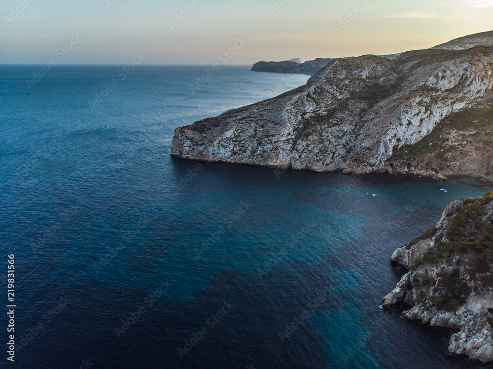 Foto Stock Summer 2018, Xabia, Javea, Valencia, Spain,Playa de la  Granadella. Sunset view of cape rock formation wild Granadella beach.  Panoramic aerial photo from drone. | Adobe Stock