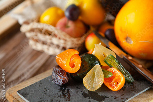 Mix of dried glazed fruits in syrup on wooden background photo