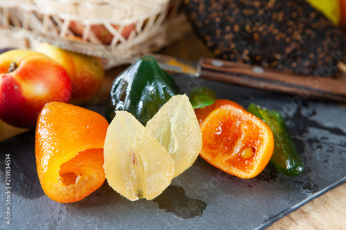 Mix of dried glazed fruits in syrup on wooden background photo