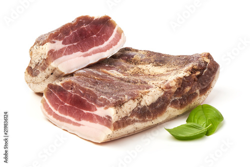 Smoked rustic farmer meat with basil leaves, isolated on white background.