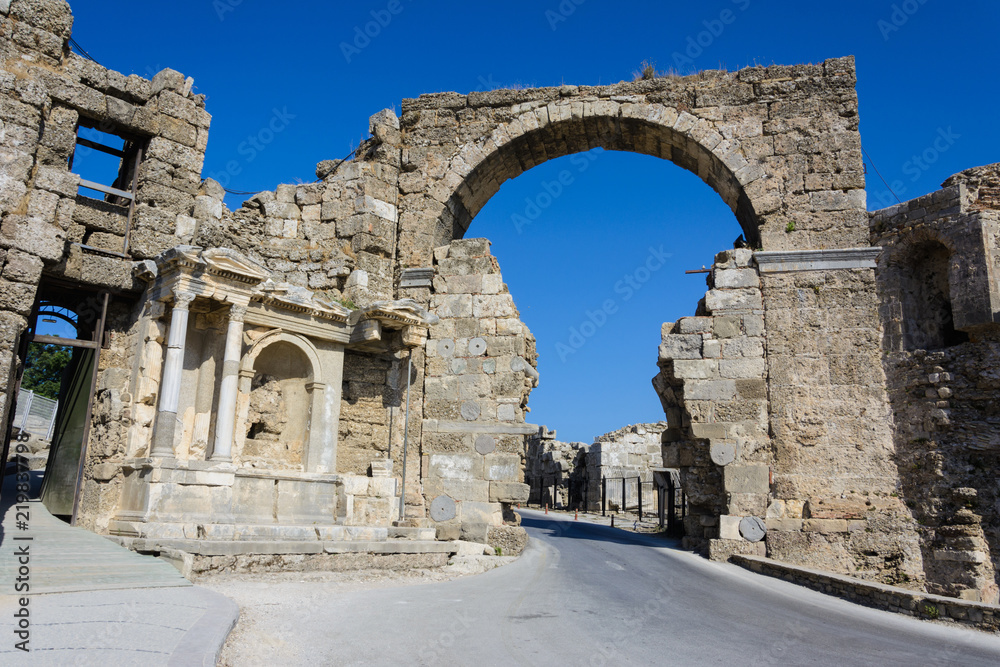 the triumphal arch and the ruins of the monument of Vespasian and Titus in the ancient city. Side, Turkey