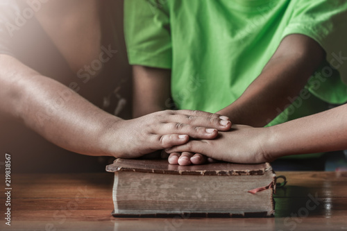 christian children small group put hands together on the Bible  prayer meeting concept