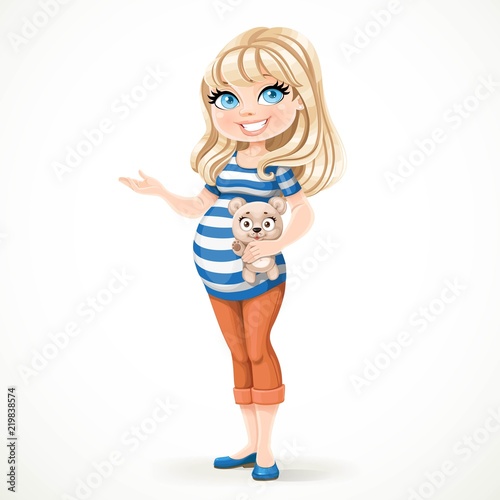Beautiful pregnant woman in a striped T-shirt is holding a teddy bear in her hand and something tells it pointing to the side isolated on a white background