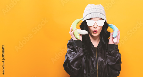 Obraz na plátně Fashionable woman in quirky trend concept with painted fruit on a solid backgrou