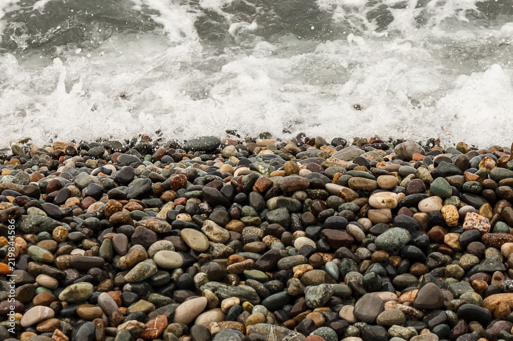 waves of the blue sea on a pebble beach. small pebble stones by the sea. waves of the blue sea on a pebble beach. small pebble stones by the sea.