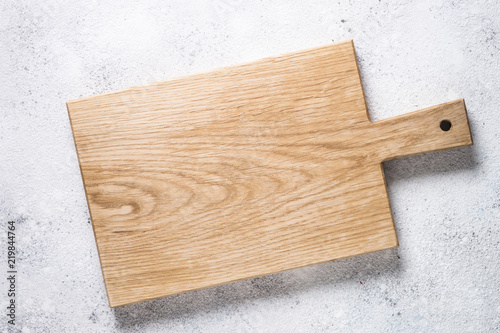 Empty wooden cutting board on white stone table.