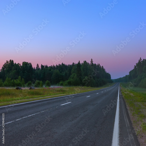 Empty Straight Asphalt Road At Dusk On A Misty Morning