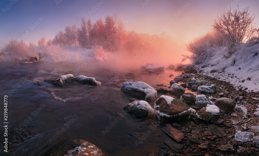 Winter Landscape In Pink Tones: Frosty Morning, River Blurred Water,Stones In Frazil And Sun In Fog.Belarus Landscape With Snowy Trees, Beautiful Frozen Foggy River And Winter Forest At Sunrise.