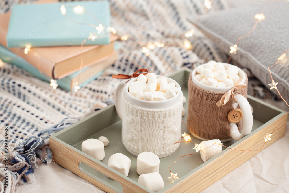Hot chocolate with marshmallows on soft plaid background with Christmas lights. Perfect winter time treat.