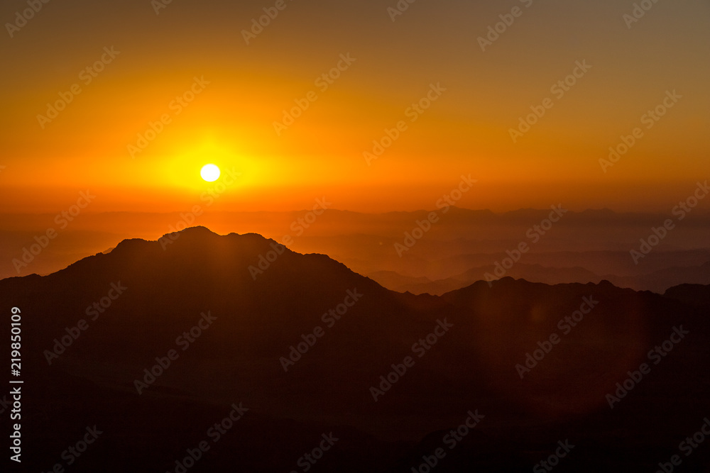 Image of a sunset. sun goes down over the mountains in the background. Mountain landscape.