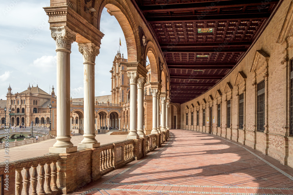 Fototapeta premium The porticoed gallery and hallway with columns and tiled floor in Plaza de Espana, Seville Spain