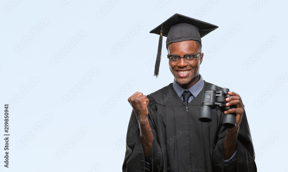 Young graduated african american man looking for a job using binoculars screaming proud and celebrating victory and success very excited, cheering emotion Young graduated african american man looking for a job using binoculars screaming proud and celebrating victory and success very excited, cheering emotion