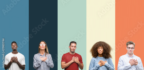 Group of people over vintage colors background smiling with hands on chest with closed eyes and grateful gesture on face. Health concept. photo