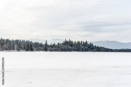 Frozen Kirchsee lake, Bavaria, with Alps in background, in winter © irottlaender