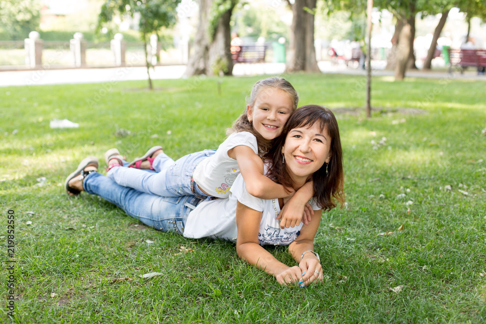 daughter and father on the lawn.in a white t-shirt and jeans. a walk in the Park. child. father and daughter. summer. daughter and father on the lawn.in a white t-shirt and jeans. a walk in the Park. child. father and daughter. summer.