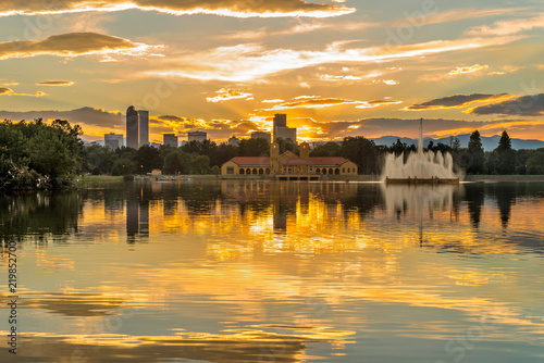 Fototapeta Naklejka Na Ścianę i Meble -  Golden Sunset at City Park - A summer sunset view of Ferril Lake in Denver City Park, with city skyline and front range mountains in the background, at east-side of Downtown Denver, Colorado, USA.