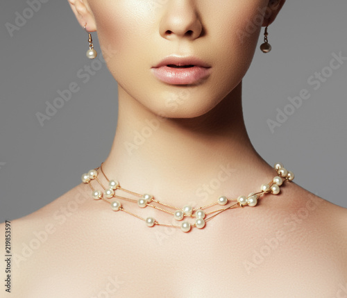 Beautiful woman in a necklace, earrings. Model in jewelry from precious stones, diamonds. Beautiful part of female face. Perfect clean skin