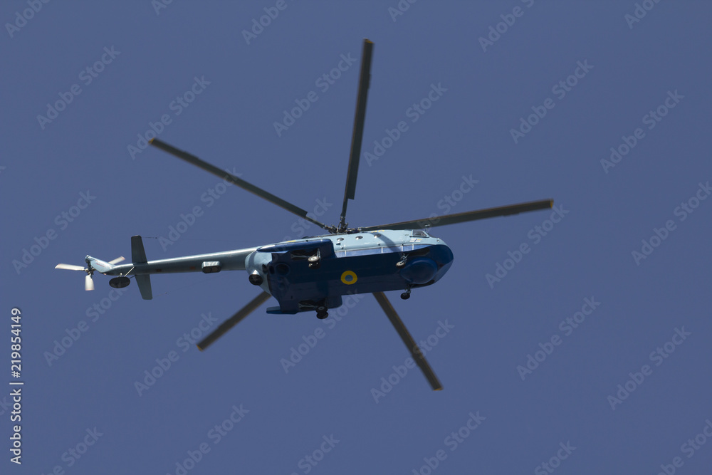Military helicopter maneuvers in the blue sky Military helicopter maneuvers in the blue sky