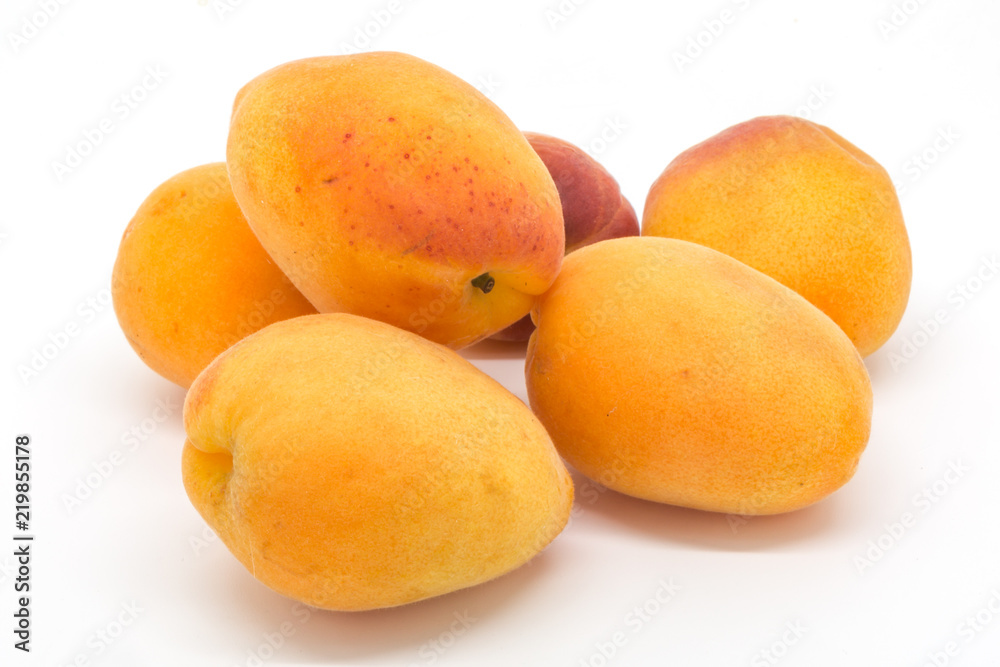 A group of fresh apricots against a white background