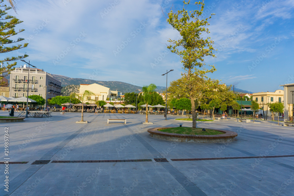 Fototapeta premium Vallianou square, the central square of Argostoli city in Kefalonia ionian island in Greece. The square is paved with many trees and palms. 