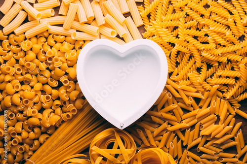 Table full of different types of pasta with a heart shape in the middle, pasta lovers