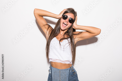 Stylish fashion bad crazy girl in sunglasses scream holding her head on white background