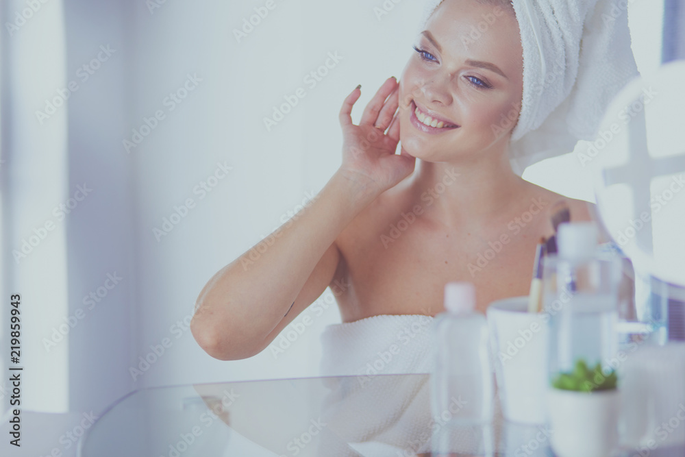 Young beautiful woman making make-up near mirror,sitting at the desk Young beautiful woman making make-up near mirror,sitting at the desk