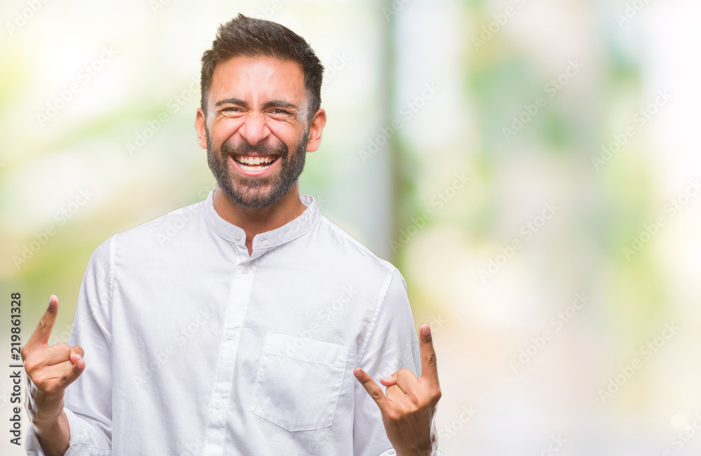 Adult hispanic man over isolated background shouting with crazy expression doing rock symbol with hands up. Music star. Heavy concept. Adult hispanic man over isolated background shouting with crazy expression doing rock symbol with hands up. Music star. Heavy concept.