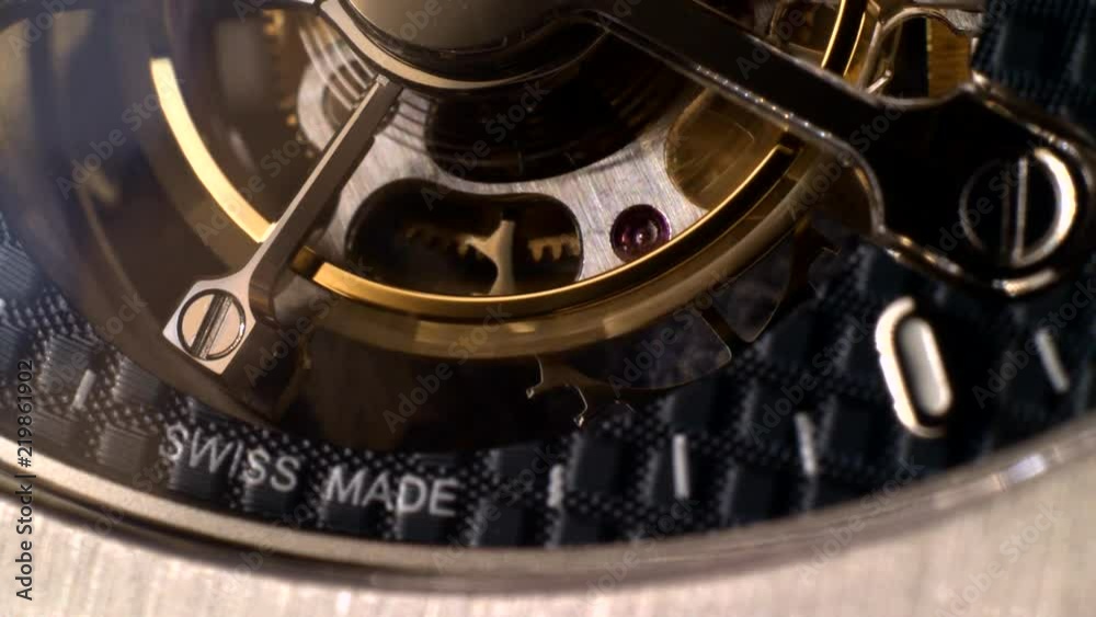 Mechanism of a watch with jewels. Open clockwork and fragments of shiny gears. Close up 4k macro shot. Time and work concept.