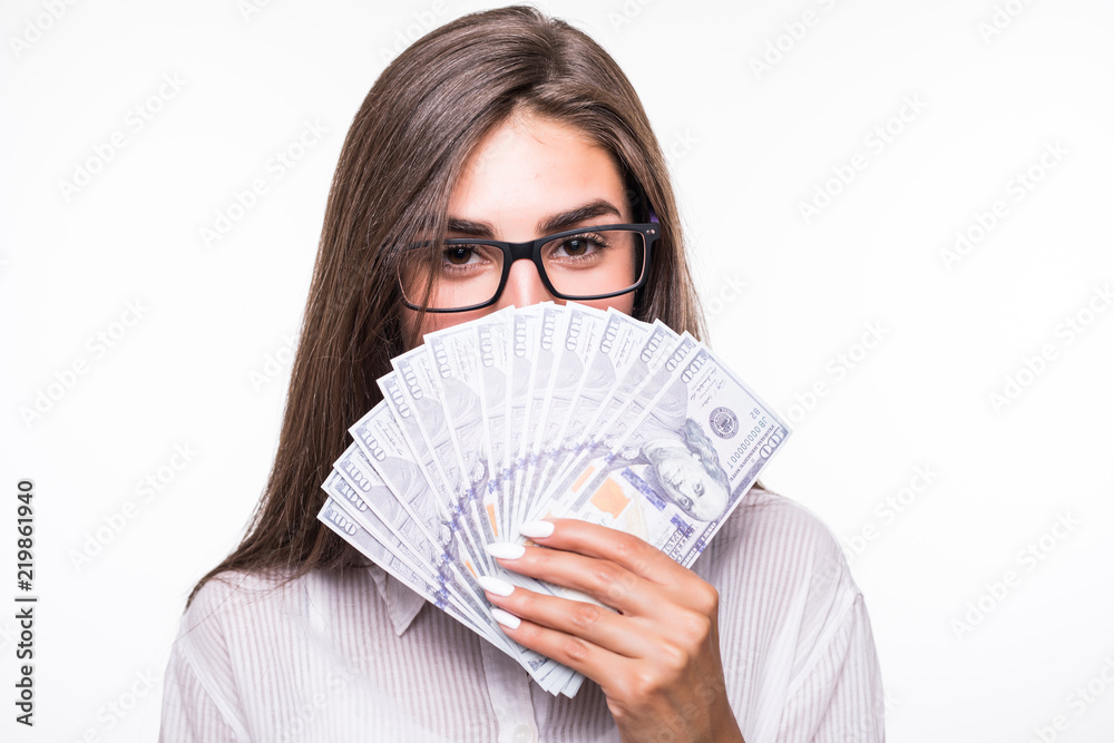 Portrait of pretty businesss woman covering closing half face with fan from dollars looking out with eyes at camera isolated on white background Portrait of pretty businesss woman covering closing half face with fan from dollars looking out with eyes at camera isolated on white background